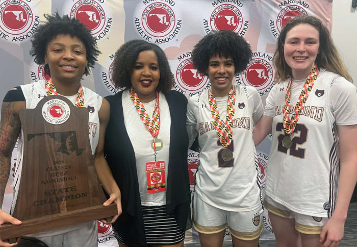 (From left) Nia Green, head coach Ayanna Jones, Asia Mitchell and Sara Yarnell celebrate Hammond's first MPSSAA girls basketball state championship, with the Class 2A trophy, during the post-game press conference.